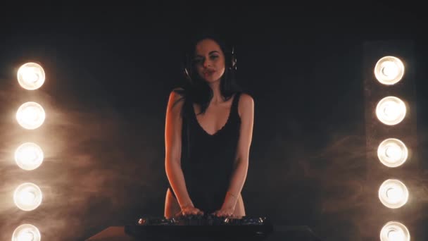 Menina DJ em fones de ouvido jogando em toca-discos — Vídeo de Stock