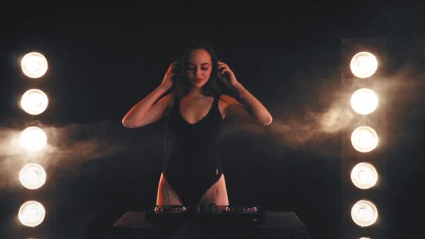 Jeune fille DJ dans les écouteurs jouant sur les platines — Video