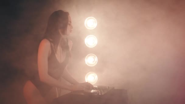 Chica DJ en auriculares jugando en los tocadiscos — Vídeos de Stock
