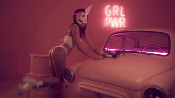 Сексуальная женщина-диджей, играющая на розовом автомобиле — стоковое видео