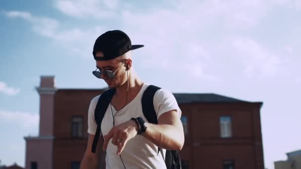 Молодий чоловік танцює в навушниках у місті — стокове відео