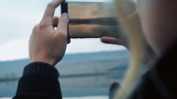 Женщина фотографируется со смартфоном — стоковое видео