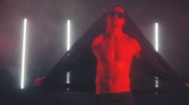 Kırmızı ışıkta dans eden seksi adam