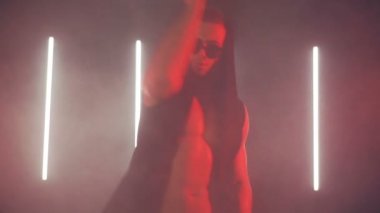 Kırmızı ışıkta dans eden seksi adam