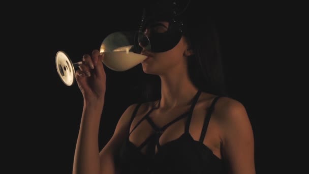 Девушка в кошачьей маске пьет молоко в стакане — стоковое видео
