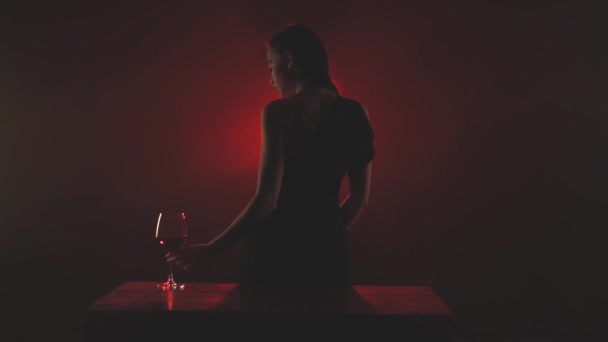 Frau mit einem Glas Rotwein in rotem Rauch — Stockvideo
