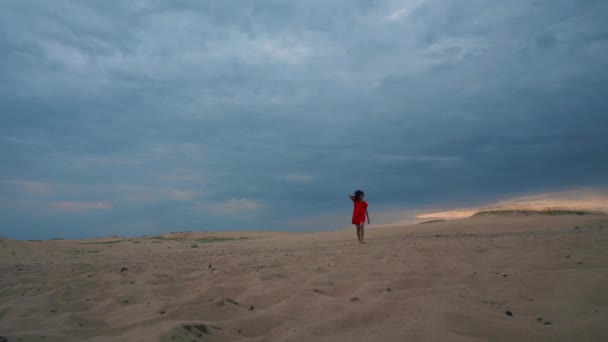 Mujer en vestido rojo caminando en el desierto — Vídeos de Stock