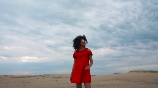 Retrato de una hermosa mujer afroamericana vestida de rojo sobre el fondo del cielo — Vídeo de stock