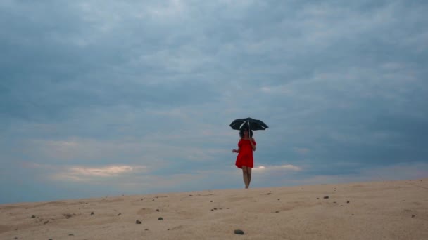 Γυναίκα που περπατάει στην έρημο με ομπρέλα — Αρχείο Βίντεο