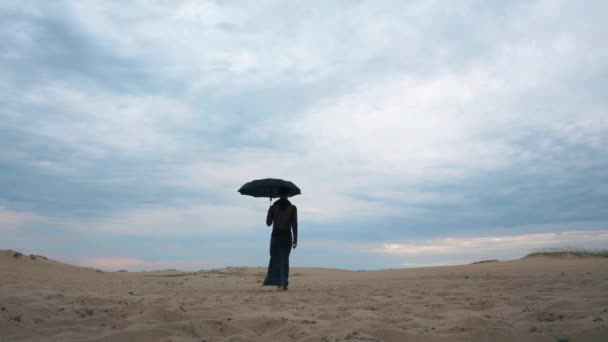 Nő a séta a sivatagban esernyő