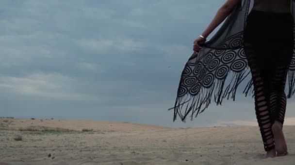Женщина в черном ходит по пустыне — стоковое видео