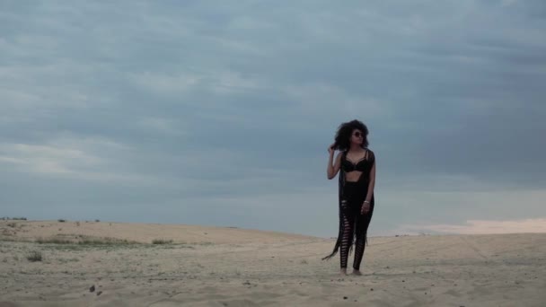 Frau in Schwarz läuft in Wüste — Stockvideo