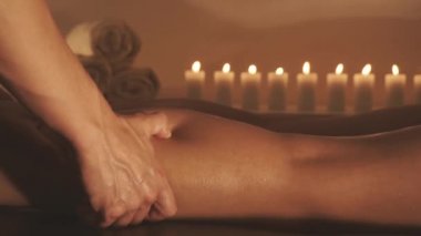Genç kadın tatil spa salonunda yağ ile bacaklar masaj oluyor