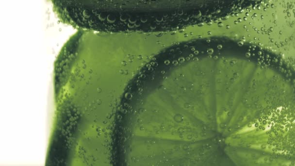 Sparkling bubbles water with a slice of lime — Stock Video