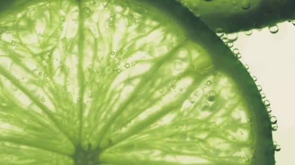 Burbujas chispeantes agua con una rebanada de cal — Vídeo de stock