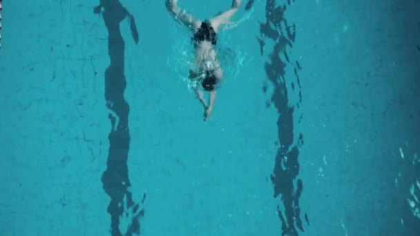 Mujer joven en piscina cubierta — Vídeo de stock
