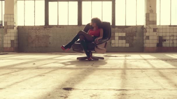 Seksi kadın ışık ışınları bir sandalyede oturur — Stok video