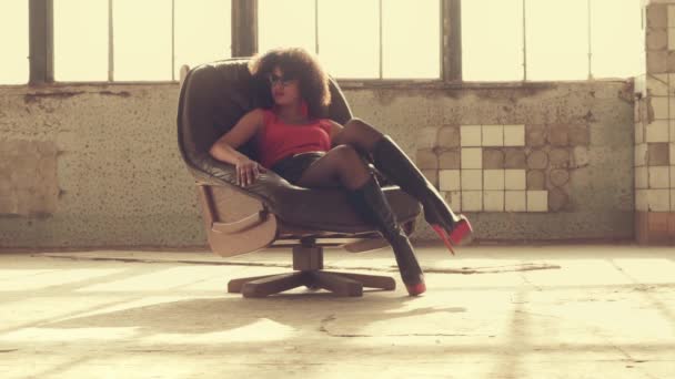 Сексуальная женщина сидит в кресле в лучах света — стоковое видео