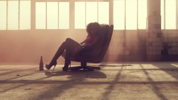 Seksowna kobieta siedzi na krześle w promieniach światła — Wideo stockowe
