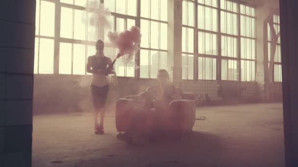 Woman in gas mask with a red bottle of smoke and man in an armchair — Stock Video