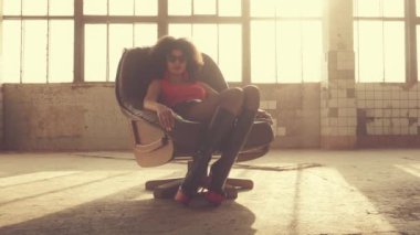 Seksi kadın ışık ışınları bir sandalyede oturur