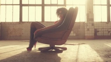 Seksi kadın ışık ışınları bir sandalyede oturur