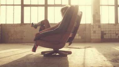 Seksi kadın ışık ışınları bir sandalyede oturur