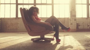 Seksi kadın ışık ışınları bir sandalyede oturur