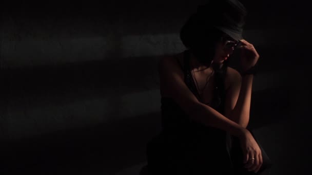 Жінка в капелюсі і окулярах у світлі — стокове відео