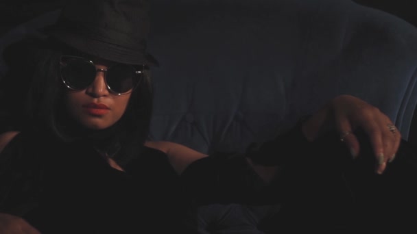 Γυναίκα κάθεται σε καπέλο και γυαλιά — Αρχείο Βίντεο
