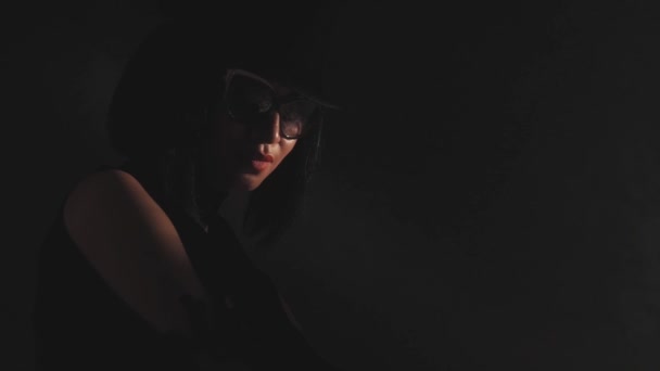 Femme au chapeau et lunettes de soleil dans l'ombre — Video