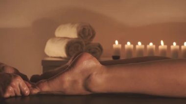 Genç kadın tatil spa salonunda yağ ile bacaklar masaj oluyor