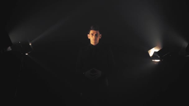 Omul în negru în raze de lumină și fum — Videoclip de stoc
