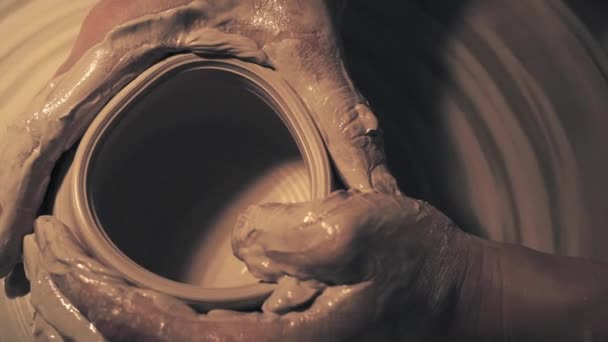 Frauenhände arbeiten an einer Töpferscheibe. Die Schaffung eines Keramiktopfes