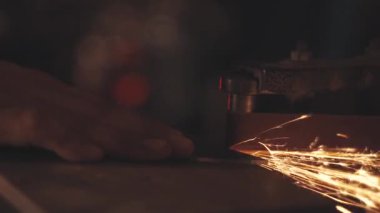 Kıvılcımlarla bıçak keskinleştiren adam. Bir keskinleştirme makinesi üzerinde çalış.