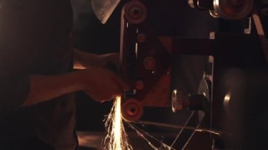 Kıvılcımlarla bıçak keskinleştiren adam. Bir keskinleştirme makinesi üzerinde çalış.