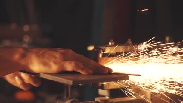 Mann schleift Messer mit Funken. Arbeit an einer Schärfmaschine. — Stockvideo