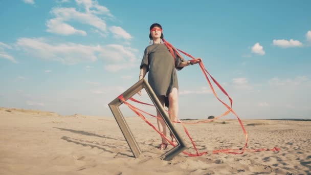 Мода. Женщина с завязанными глазами с картинкой в пустыне — стоковое видео