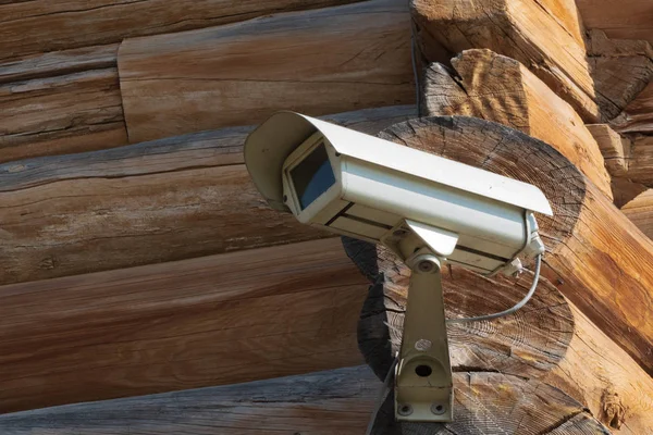 Closeup of video camera screwed to the corner of the log house