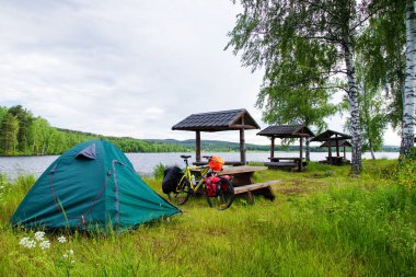 DALARNA, SWEDEN - 18 Haziran 2012 'de İsveç' in Dalarna eyaletinde göl kenarında bisiklet çadırı kuruldu. Doğaya sınırsız erişim neredeyse her yerde çadır kurulmasına izin verir..