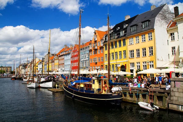 COPENHAGEN, DENMARK - 28 Temmuz 2011 'de Danimarka' nın Kopenhag kentindeki Nyhavn gezinti alanında güneşli havanın tadını çıkaran kimliği belirsiz kişiler. Nyhavn Kopenhag 'ın en ünlü simgelerinden biridir..
