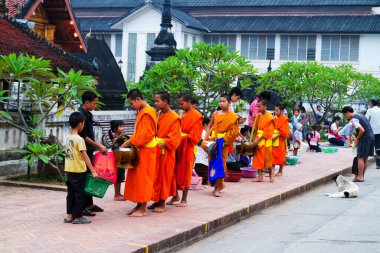 LUANG PRABANG, LAOS - SEPTEMBER15; Tanımlanamayan keşişler 15 Eylül 2012 'de bağış ve bağış toplamak için yürürler. Bu tören her gün sabah erkenden Luang Prabang 'da düzenlenir.
