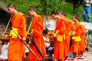 LUANG PRABANG, LAOS - SEPTEMBER15; Tanımlanamayan keşişler 15 Eylül 2012 'de bağış ve bağış toplamak için yürürler. Bu tören her gün sabah erkenden Luang Prabang 'da düzenlenir.
