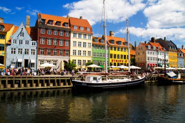 COPENHAGEN, DENMARK - 28 Temmuz 2011 'de Danimarka' nın Kopenhag kentindeki Nyhavn gezinti alanında güneşli havanın tadını çıkaran kimliği belirsiz kişiler. Nyhavn Kopenhag 'ın en ünlü simgelerinden biridir..