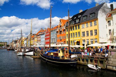 COPENHAGEN, DENMARK - 28 Temmuz 2011 'de Danimarka' nın Kopenhag kentindeki Nyhavn gezinti alanında güneşli havanın tadını çıkaran kimliği belirsiz kişiler. Nyhavn Kopenhag 'ın en ünlü simgelerinden biridir..