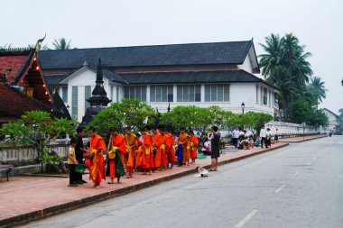 LUANG PRABANG, LAOS - SEPTEMBER15; Tanımlanamayan keşişler 15 Eylül 2012 'de bağış ve bağış toplamak için yürürler. Bu tören her gün sabah erkenden Luang Prabang 'da düzenlenir.