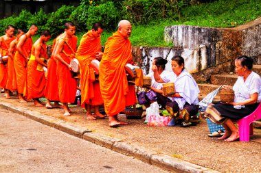 LUANG PRABANG, LAOS - SEPTEMBER15; Tanımlanamayan keşişler 15 Eylül 2012 'de bağış ve bağış toplamak için yürürler. Bu tören her gün sabah erkenden Luang Prabang 'da düzenlenir.