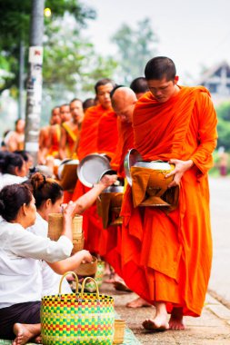 LUANG PRABANG, LAOS - SEPTEMBER15; Tanımlanamayan keşişler 15 Eylül 2012 'de bağış ve bağış toplamak için yürürler. Bu tören her gün sabah erkenden Luang Prabang 'da düzenlenir.