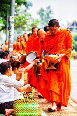 LUANG PRABANG, LAOS - SEPTEMBER15; Tanımlanamayan keşişler 15 Eylül 2012 'de bağış ve bağış toplamak için yürürler. Bu tören her gün sabah erkenden Luang Prabang 'da düzenlenir.