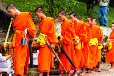 LUANG PRABANG, LAOS - SEPTEMBER15; Tanımlanamayan keşişler 15 Eylül 2012 'de bağış ve bağış toplamak için yürürler. Bu tören her gün sabah erkenden Luang Prabang 'da düzenlenir.